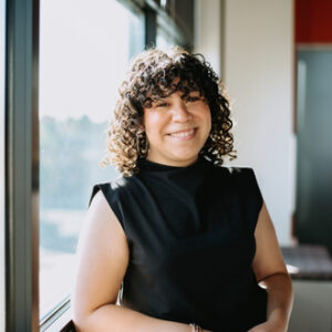 PW staff member posing for the camera in front of a window.